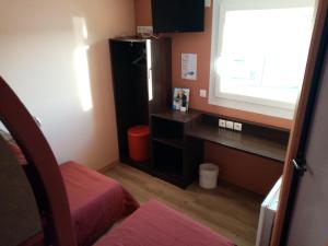 a small room with a desk and a window at Brit Hotel St-Quentin/Nord in Saint-Quentin