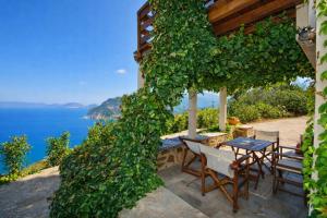 Ein Tisch und Stühle auf einer Terrasse mit Blick auf das Meer in der Unterkunft Stolios Skopelos - Panoramic Seaview Gems in Skopelos
