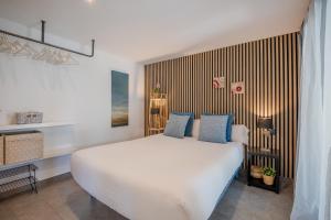a bedroom with a large white bed with blue pillows at Flateli Montjuïc in Girona +32 photos