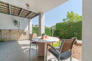 a patio with a table and chairs and a fence at Flateli Montjuïc in Girona