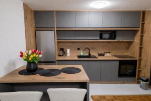 a kitchen with a table with a vase of flowers on it at Apartman Anja'K in Doboj