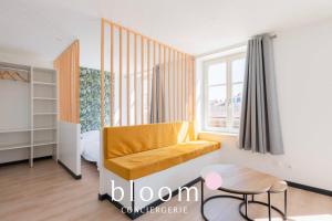a living room with a yellow couch and a window at Le Soleil du Marché central in Nancy