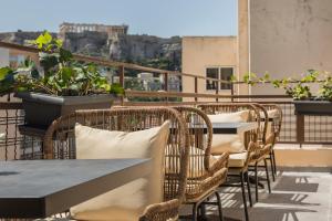 a table and chairs on a balcony with a view at Royalty Hotel Athens in Athens