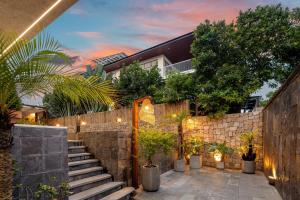 a house with a stone wall and stairs at Sora Villa, Huge Swimming Pool, Private Sauna & Elevator Access in Danang