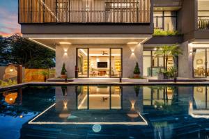 a house with a swimming pool in front of it at Sora Villa, Huge Swimming Pool, Private Sauna & Elevator Access in Danang