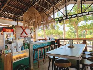 a bar with a table and chairs in a restaurant at Beach People Hostel Bantayan Island in Ocoy