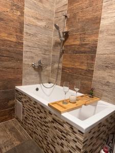 a bathroom with a bath tub with two wine glasses at Apartmán 6 in Spišské Podhradie +42 photos