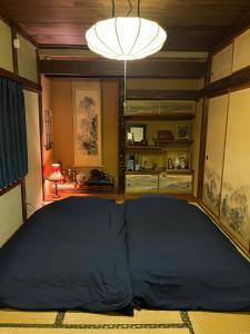 a large bed in a room with a lamp at Lodging House NAO in Aomori