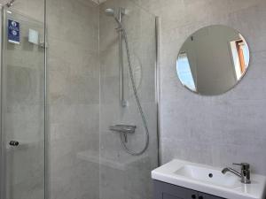 a bathroom with a shower and a sink and a mirror at Diekbude Nr 53 in Friedrichskoog +12 photos