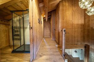 a room with wooden walls and a glass corridor at Chalet Cocoon in Combloux +31 photos