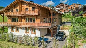 a wooden house with a car parked in front of it at Chalet Cocoon in Combloux