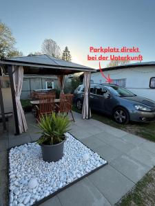 a gazebo with a table and a car parked under it at Campingwohnung am Silbersee in Freiburg in Freiburg im Breisgau