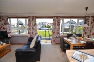 a living room with a couch and a table at Kingfisher Lodge in Wroxham