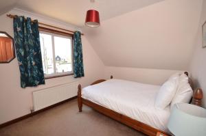 a bedroom with a bed and a window at Kingfisher Lodge in Wroxham