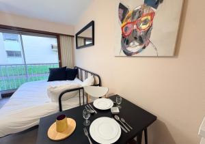 a bedroom with a bed and a table with plates on it at Studio Cosy Carnot in Compiègne