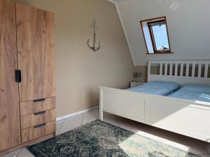 a bedroom with a bed and a dresser and a mirror at Diekbude Nr 53 in Friedrichskoog