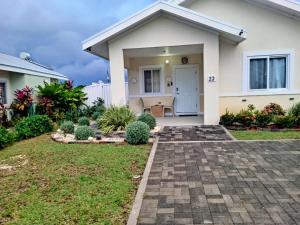 a house with a brick walkway leading to the front door at Summer Breeze Villa in Lucea