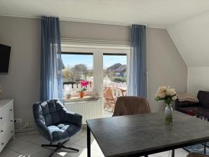 a living room with a table and chairs and a window at Diekbude Nr 53 in Friedrichskoog