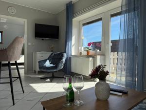 a living room with a table and two wine glasses at Diekbude Nr 53 in Friedrichskoog