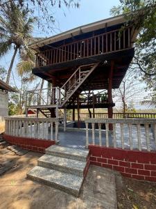 a wooden building with stairs and a stair case at YR'S Nature Farmhouse in Badlapur