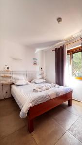 a large bed in a bedroom with a window at Hotel La Bastide in Le Lavandou