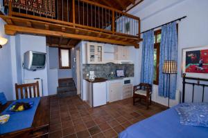 ein Zimmer mit Küche und ein Esszimmer mit Tisch in der Unterkunft Stolios Skopelos - Panoramic Seaview Gems in Skopelos