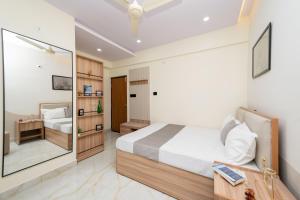 a bedroom with a bed and a mirror at C Suites Gilbert in Bangalore +27 photos
