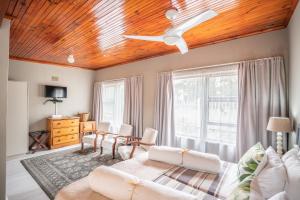 a living room with a wooden ceiling at 30 on Oatlands Accommodation Makhanda Grahamstown in Grahamstown
