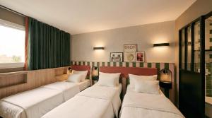 three beds are lined up in a room at Hôtel EH OH Orly Rungis in Rungis
