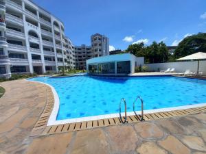 a large swimming pool in front of a building at Easy stays baobab in Mombasa