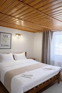 a bedroom with a large white bed and a window at Heaven Boutique in Pucioasa +4 photos