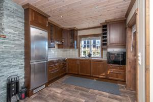 a kitchen with wooden cabinets and a stainless steel refrigerator at Rauland, Listaullii in Torvetjørn