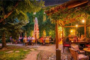 a group of people sitting at a table in a garden at Penzión ÁTRIUM in Prešov