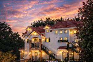 a large white house with a sunset in the background at Taean Red Balloon Pension in Taean