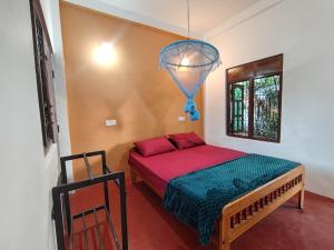 a bedroom with a bed and a window and a chandelier at The zen inn in Nikawatawana