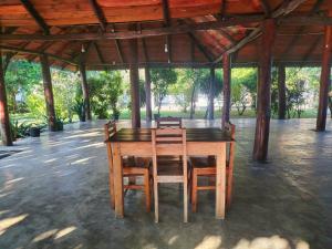 a wooden table and chairs in a pavilion at The zen inn in Nikawatawana +10 photos