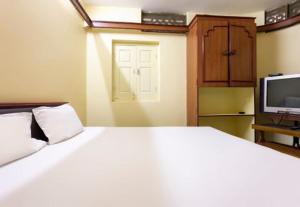 a bedroom with a large white bed and a tv at Hotel Neelkamal in Indore