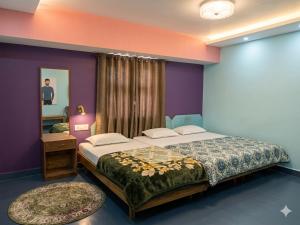 a bedroom with a large bed and a mirror at Hotel Neelkamal in Indore