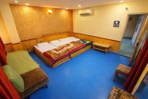a room with a bed and a couch in it at Hotel Neelkamal in Indore