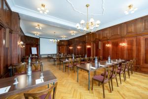 a conference room with tables and chairs and a projection screen at martas Hotel Albrechtshof Berlin in Berlin