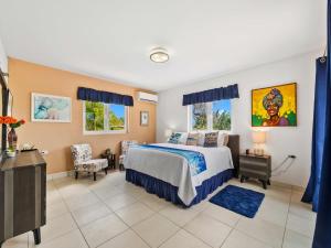 a bedroom with a bed and a desk and two windows at Villa Savannah in Savaneta +34 photos