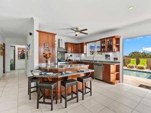 a kitchen with a large island with bar stools at Villa Savannah in Savaneta