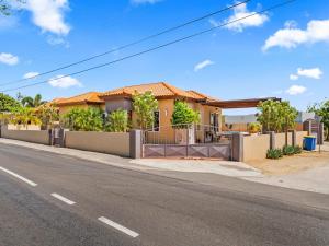 a house on the side of a street at Villa Savannah in Savaneta