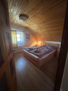 a bedroom with a bed with a wooden ceiling at Andělský sklípek in Dolní Věstonice
