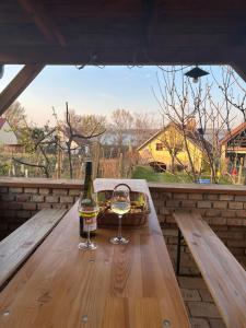 a bottle of wine and a glass on a wooden table at Andělský sklípek in Dolní Věstonice