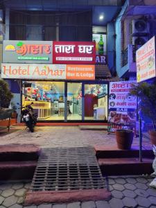 a hotel entrance at night with signs at Hotel Aahar chitawan in Bharatpur