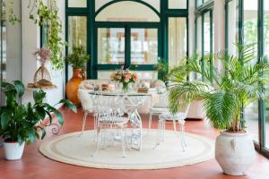 a room with a table and chairs and plants at Hotel Castello Artemide Congressi in Castel San Pietro Terme