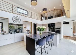 a kitchen with a large island with blue bar stools at Maison de prestige à Grimaud in Grimaud