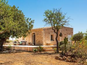 a stone house with a tree in front of it at Finca Bassa Serra in Santanyi