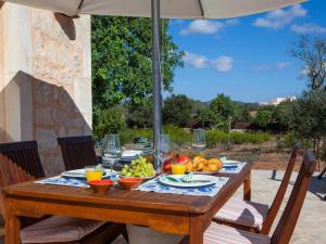 a wooden table with food on it with an umbrella at Finca Bassa Serra in Santanyi